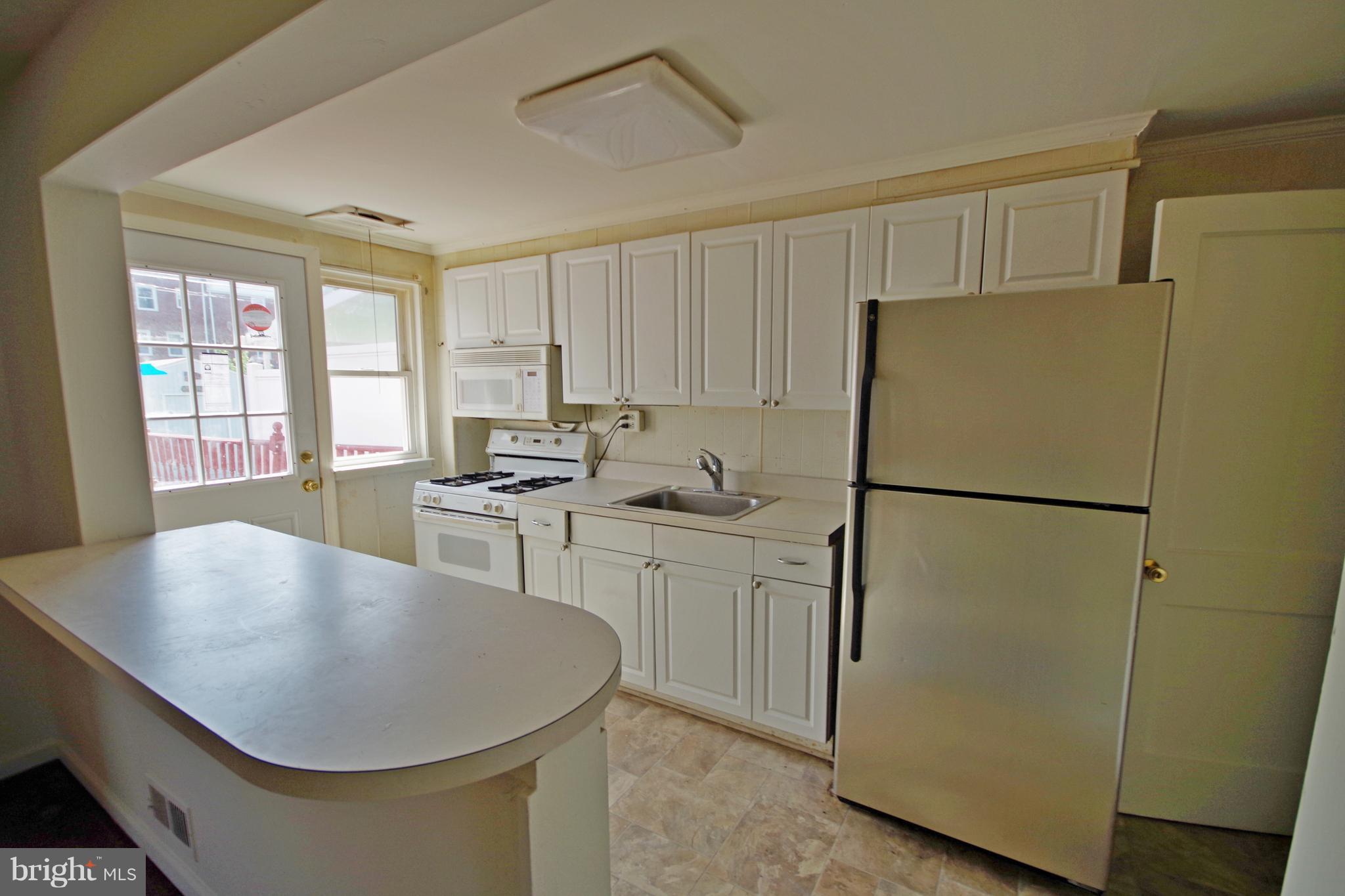 7457 Lawrence Road Dundalk, MD 21222 - Photo 8 of 24 a kitchen with refrigerator cabinets and wooden floor