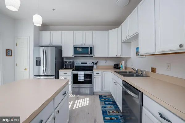 a kitchen with a sink a stove a refrigerator and cabinets