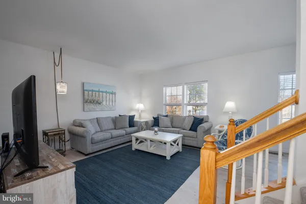 a living room with furniture flat screen tv and a window