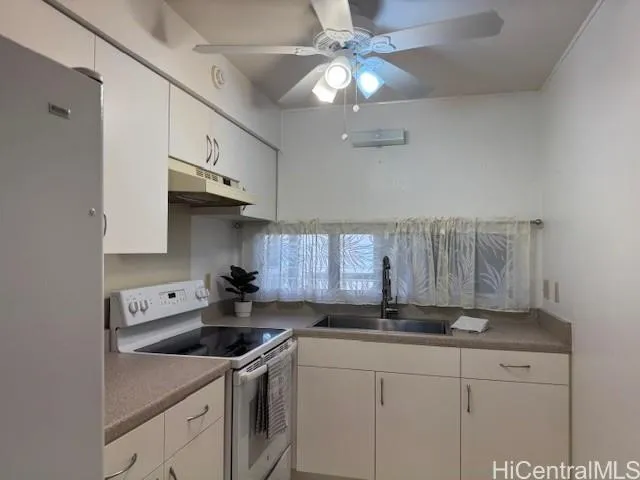 a kitchen with stainless steel appliances a sink a stove and cabinets