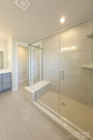 a bathroom with a tub shower and mirror