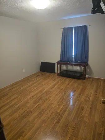 a view of a room with wooden floor and a cabinet