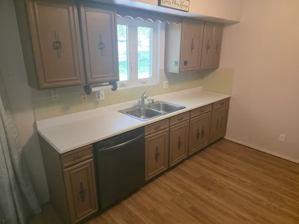 a kitchen with a sink cabinets and wooden floor