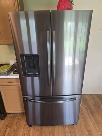a view of a refrigerator in kitchen and wooden floor