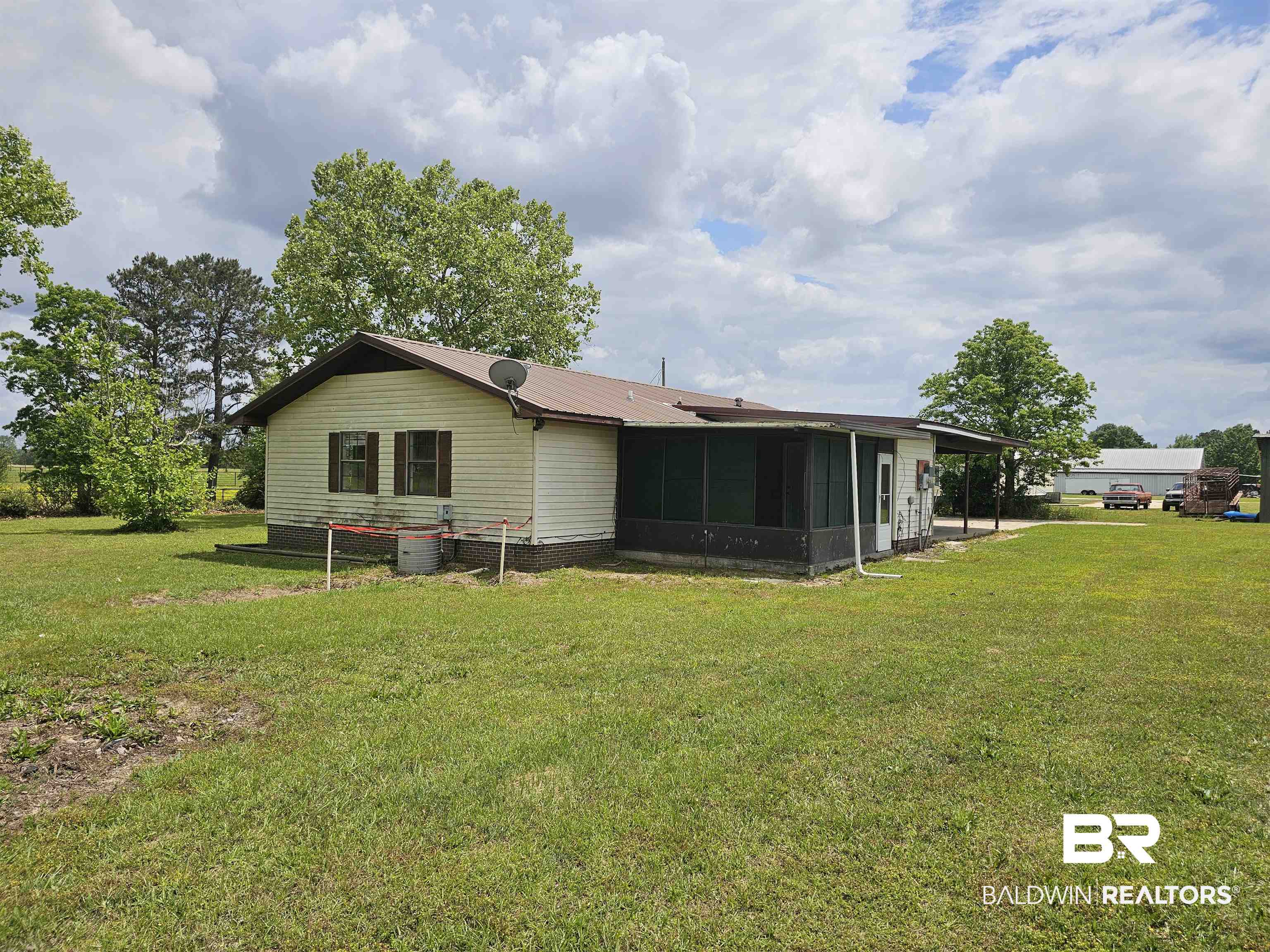 59575 Lottie Road Atmore, AL 36502 - Photo 3 of 23 Rear view of house with a yard, cooling unit, and a sunroom