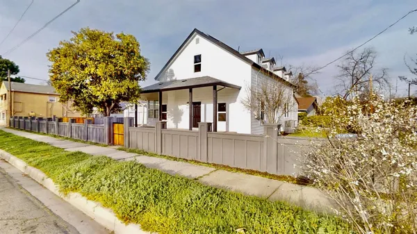 a view of a house with a small yard and potted plants