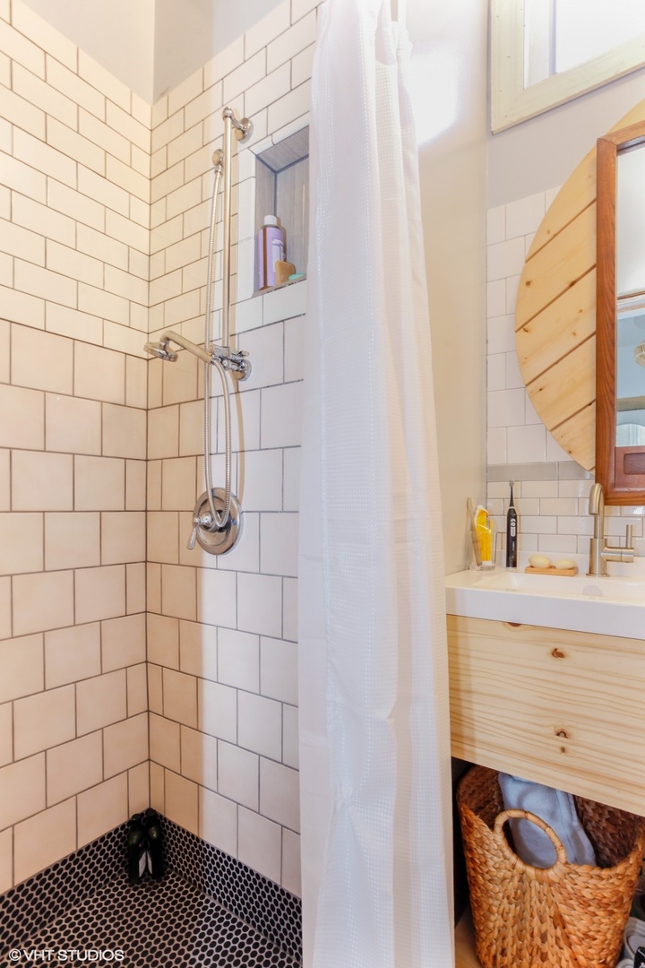 4837 West Irving Park Road, Unit 2 Chicago, IL 60641 - Photo 14 of 24 a bathroom with a sink a toilet and a shower