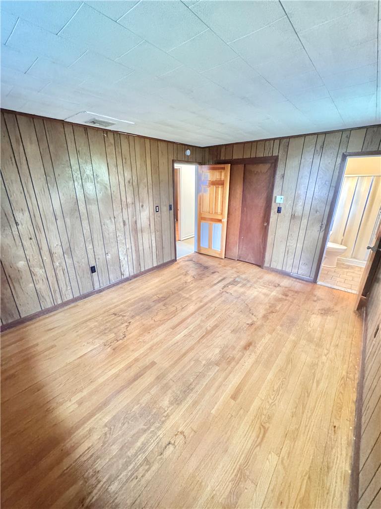 8325 Schantz Road Breinigsville, PA 18031 - Photo 15 of 21 Authentic wood-paneled walls surround a spacious bedroom with natural hardwood flooring.