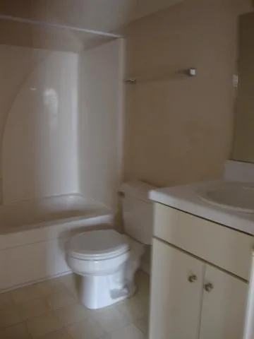 a white toilet sitting next to a shower