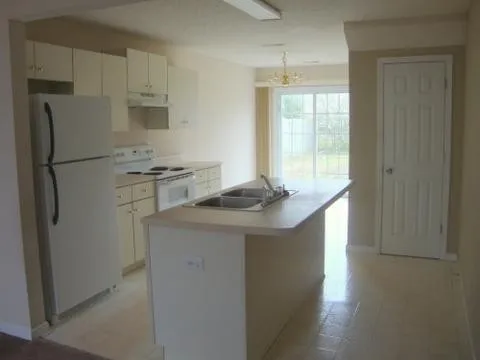 a kitchen with stainless steel appliances granite countertop a refrigerator a stove a sink and a refrigerator