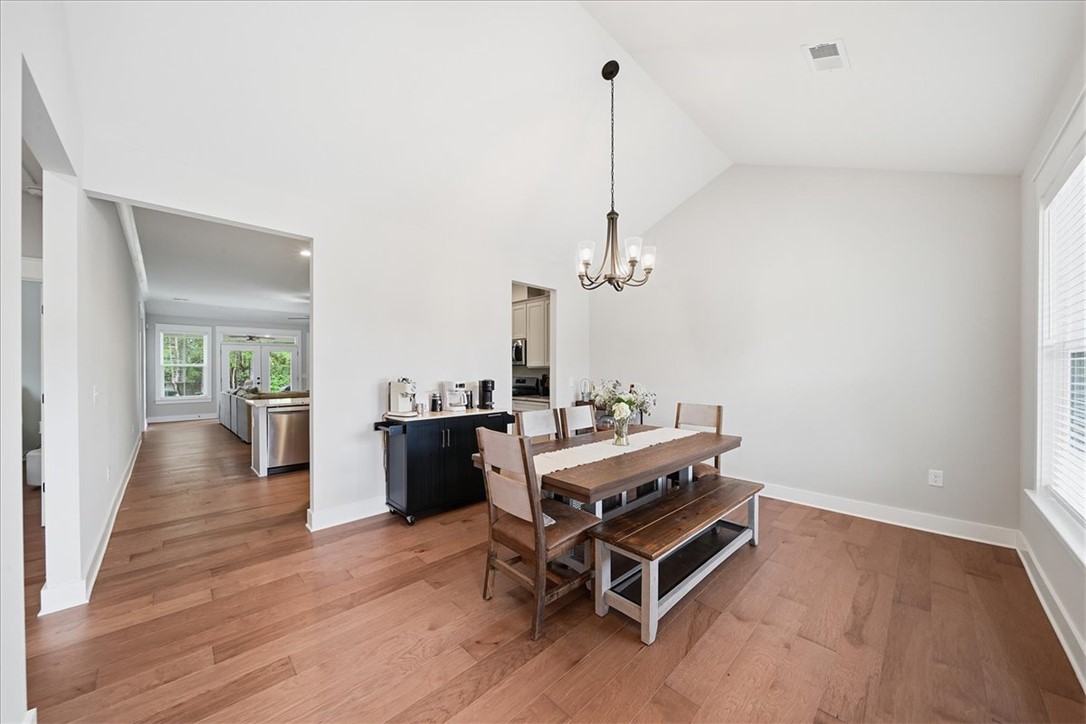 214 Timothy Court Anderson, SC 29621 - Photo 5 of 43 Hardwood flooring extends throughout this naturally illuminated dining area, featuring a modern chandelier and high ceilings.