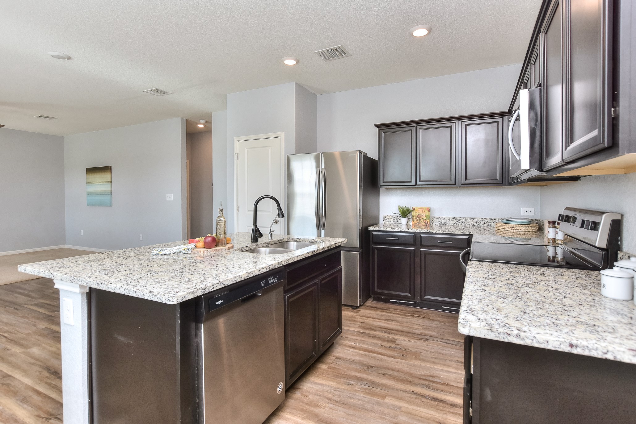 109 Helios Drive Jarrell, TX 76537 - Photo 14 of 32 a kitchen with kitchen island granite countertop a sink stove refrigerator and cabinets