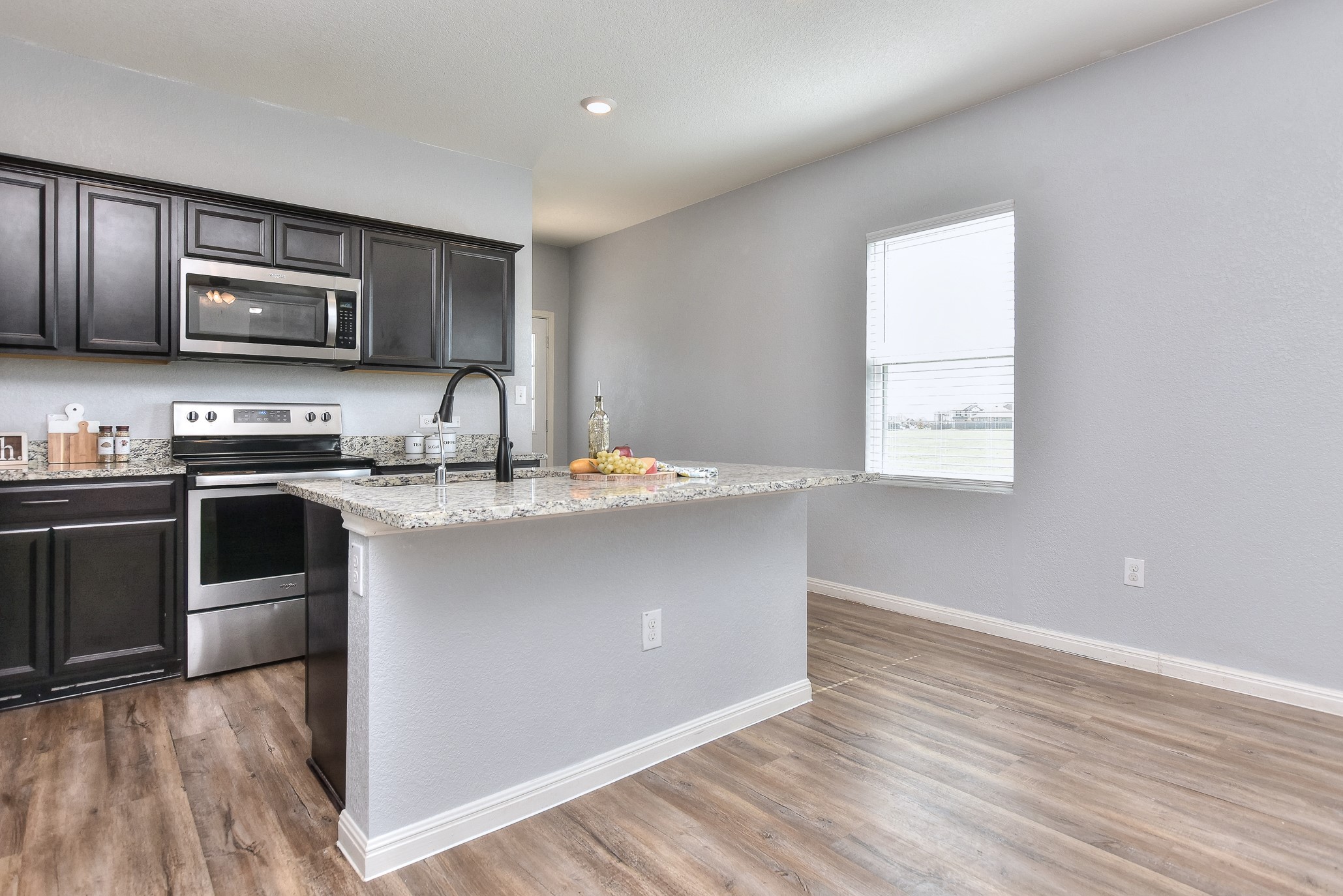 109 Helios Drive Jarrell, TX 76537 - Photo 8 of 29 a kitchen with stainless steel appliances a sink stove and microwave