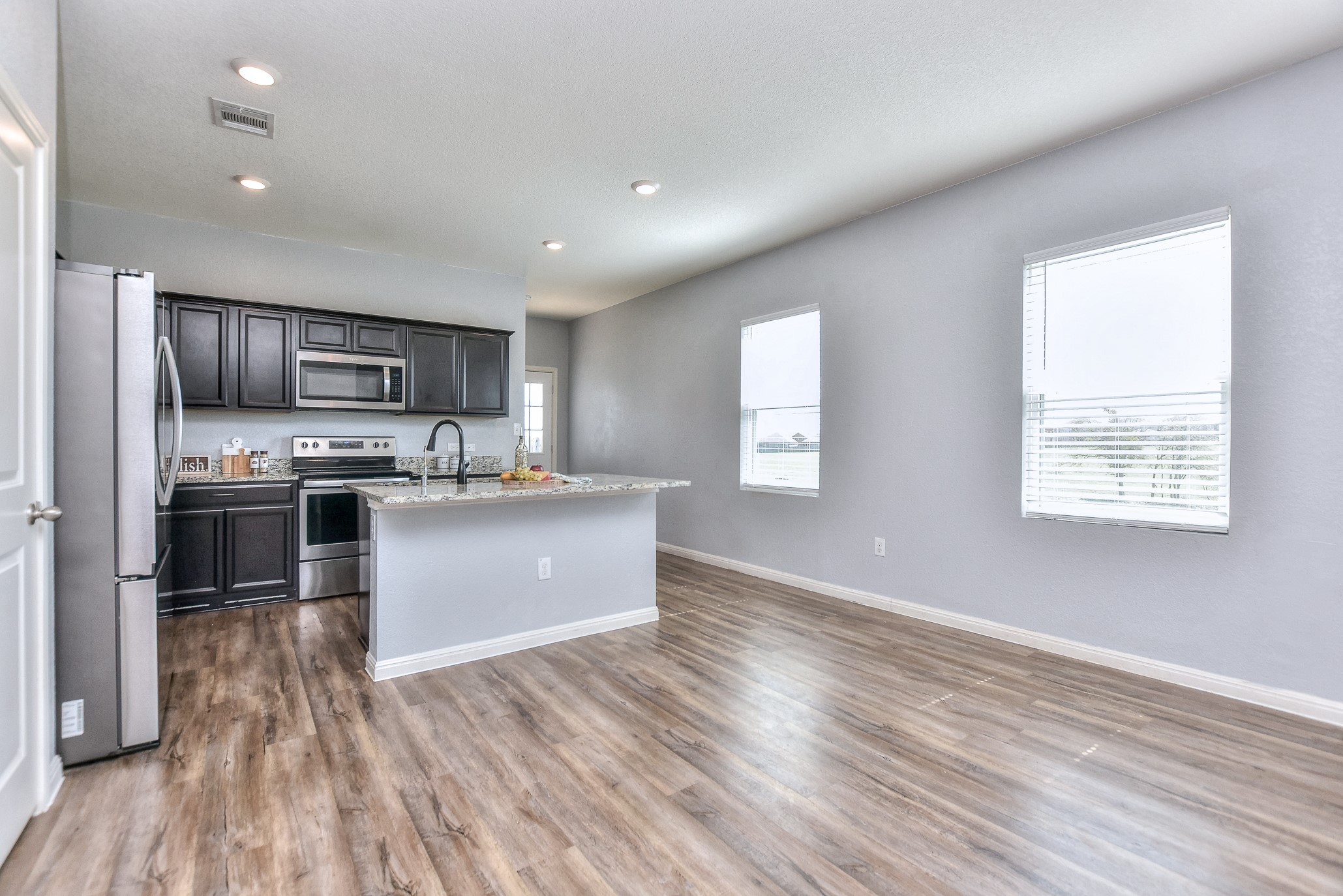 109 Helios Drive Jarrell, TX 76537 - Photo 8 of 32 a large kitchen with stainless steel appliances granite countertop a large counter top a wooden floors and white cabinets
