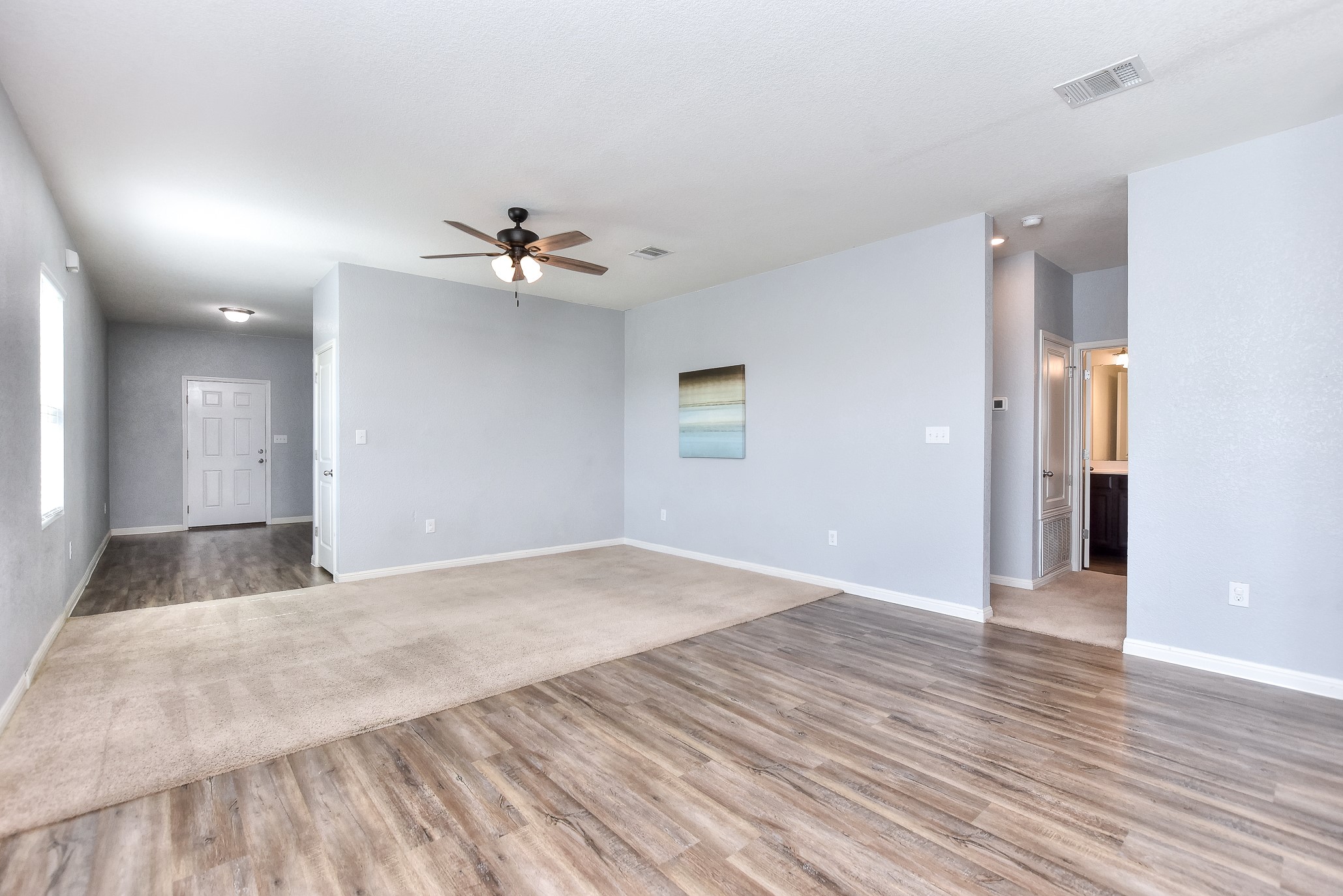 109 Helios Drive Jarrell, TX 76537 - Photo 9 of 32 an empty room with wooden floor and a ceiling fan