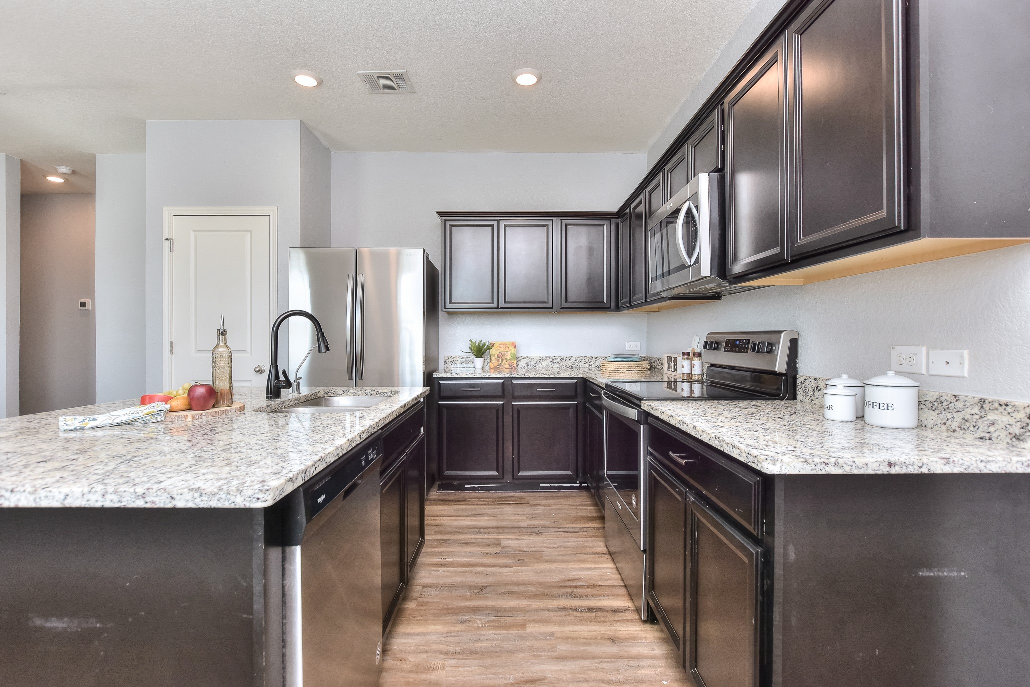 109 Helios Drive Jarrell, TX 76537 - Photo 10 of 29 a kitchen with stainless steel appliances granite countertop a sink stove and refrigerator