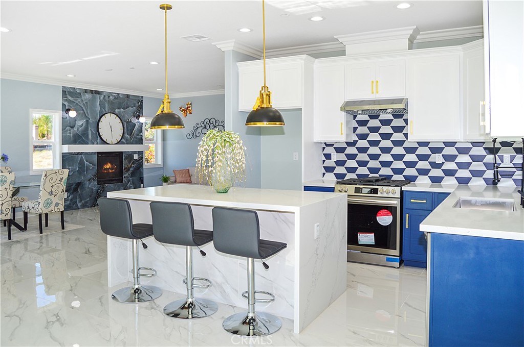 29329 Kemper Lane Highland, CA 92346 - Photo 18 of 75 a kitchen with stainless steel appliances granite countertop a stove a sink and a dining table with chairs