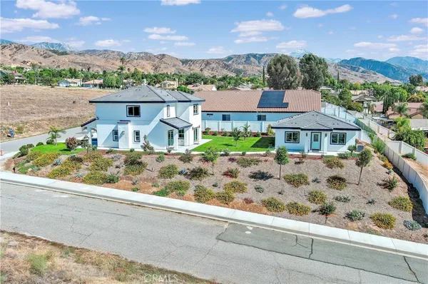 an aerial view of a house with a garden and lake view