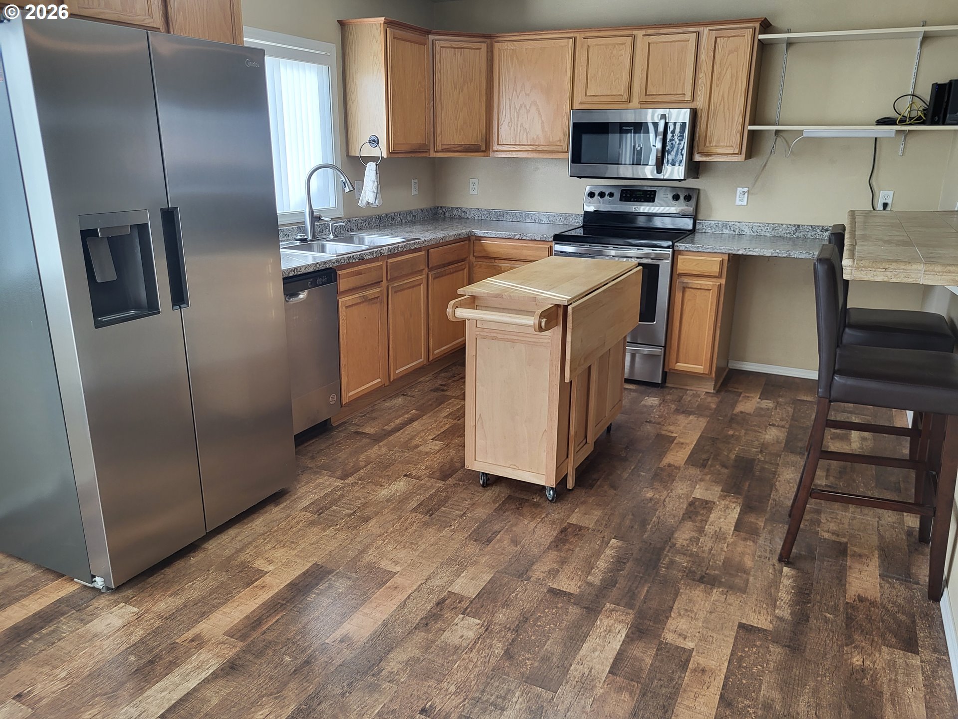 963 Crocker Street Coos Bay, OR 97420 - Photo 12 of 42 a kitchen with stainless steel appliances granite countertop a refrigerator a stove a sink and a microwave