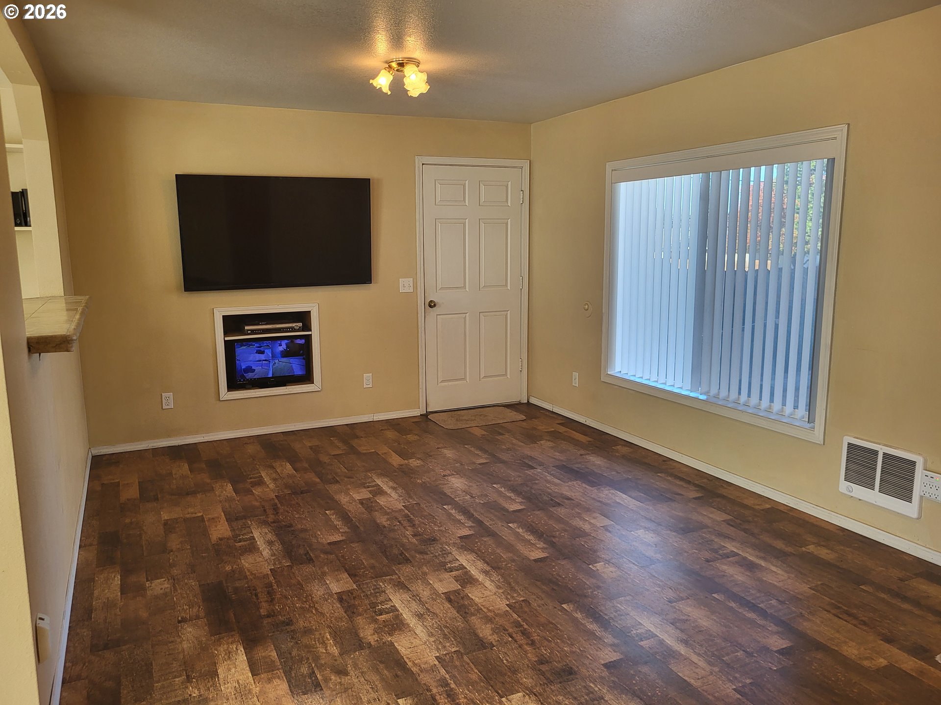 963 Crocker Street Coos Bay, OR 97420 - Photo 8 of 42 a view of an empty room with wooden floor and a flat screen tv