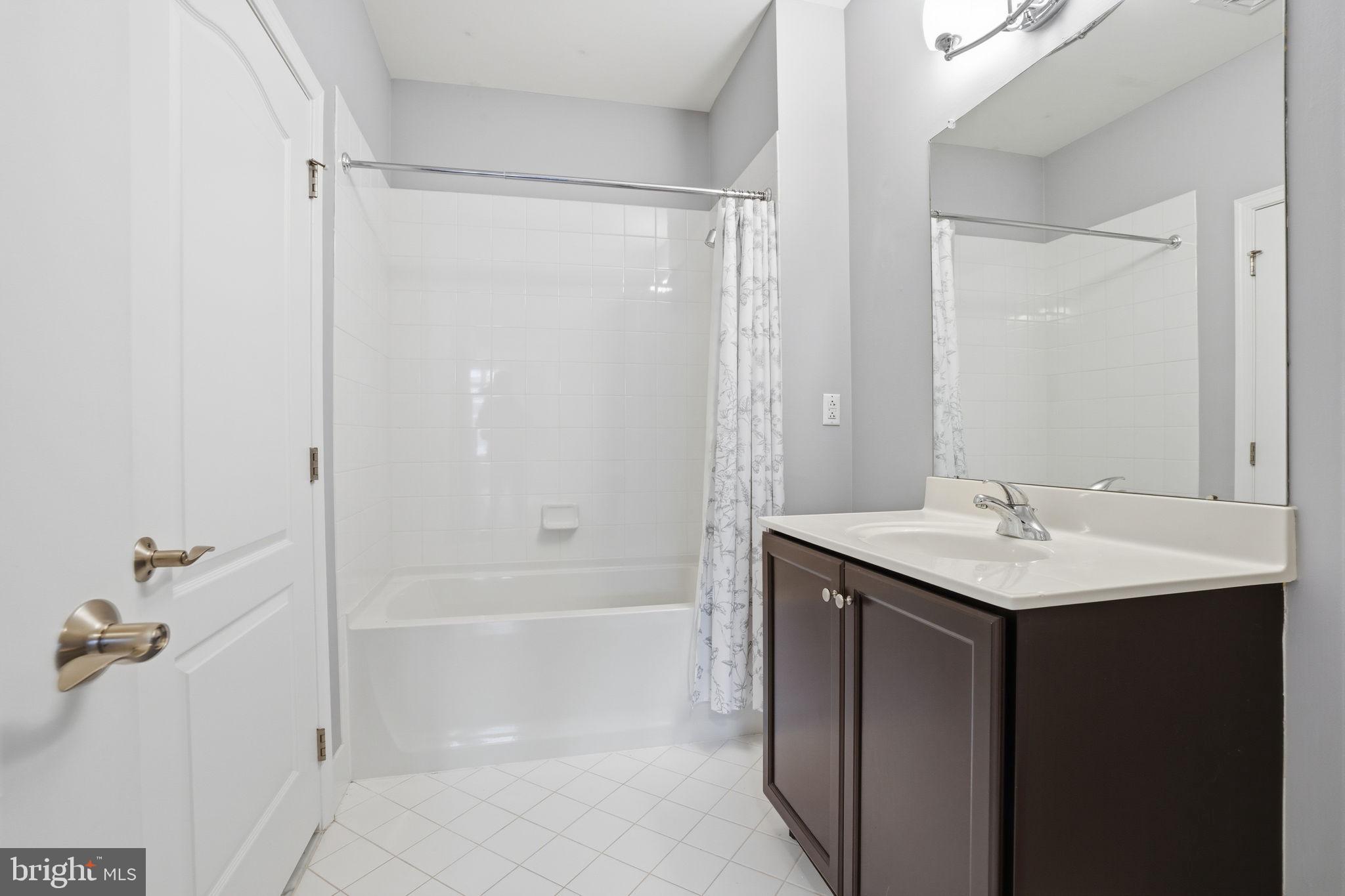 235 Carson Terrace Huntingdon Valley, PA 19006 - Photo 22 of 23 a bathroom with a granite countertop sink a mirror and a bathtub
