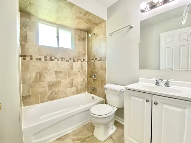 a bathroom with a granite countertop toilet a sink and a bathtub