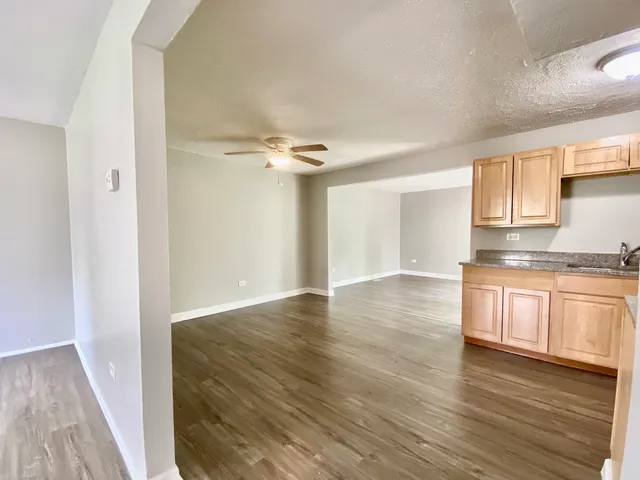 a view of a kitchen with wooden floor and a sink