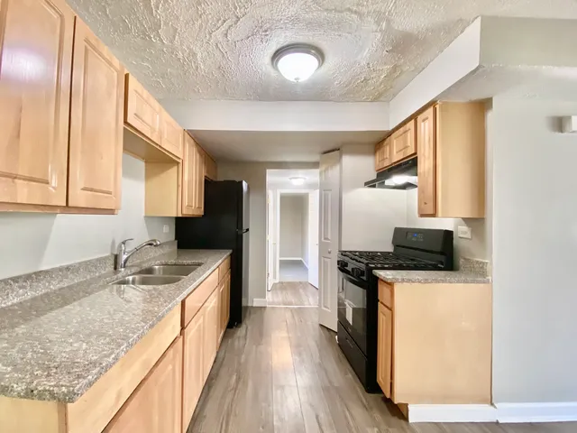 a kitchen with granite countertop a sink and a stove top oven