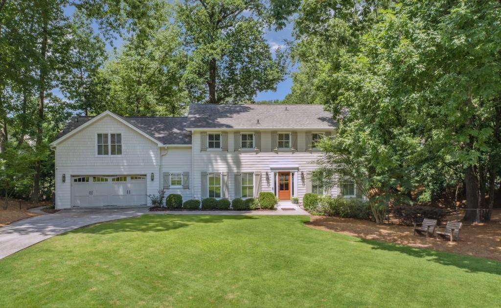 a front view of a house with a yard and trees