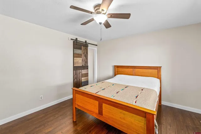a room with wooden floor and ceiling fan