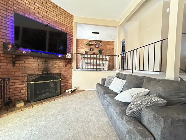 a living room with furniture a flat screen tv and a fireplace