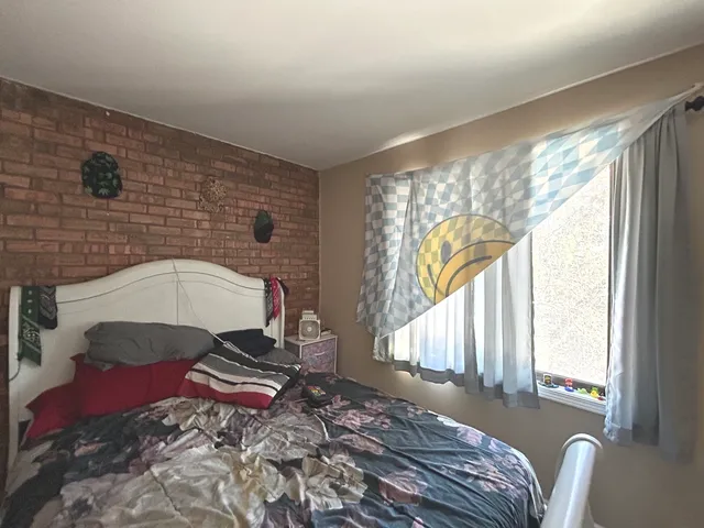 a bedroom with a bed and a large window