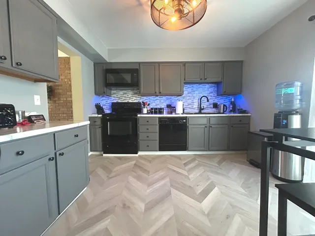 a kitchen with stainless steel appliances a stove a sink dishwasher and cabinets