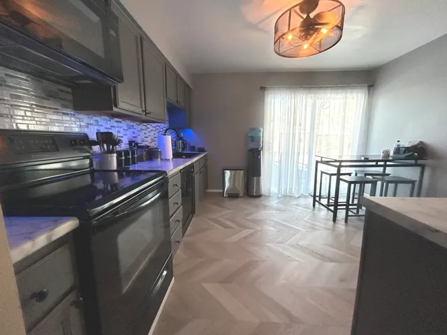 a kitchen with stainless steel appliances granite countertop a stove a sink and a microwave