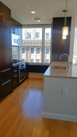 a kitchen with kitchen island granite countertop wooden cabinets and stainless steel appliances
