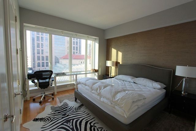 a bedroom with a bed and a large window