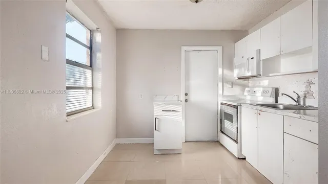 a kitchen with white cabinets and white appliances
