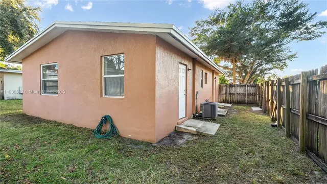 a view of a backyard with wooden fence and a bench
