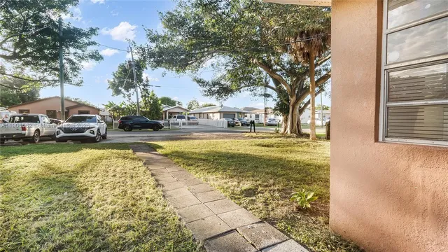 a view of swimming pool with lawn chairs and plants