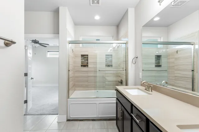 a bathroom with a granite countertop sink mirror bathtub and shower