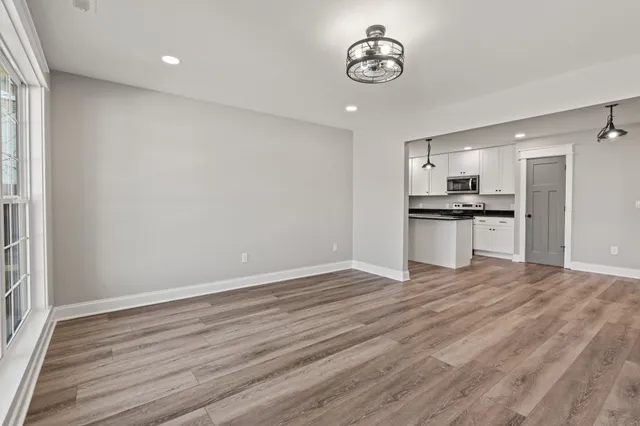 a kitchen with stainless steel appliances granite countertop a refrigerator sink and white cabinets