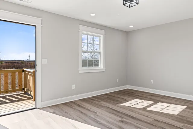 a view of a kitchen with a fridge wooden floor and a window