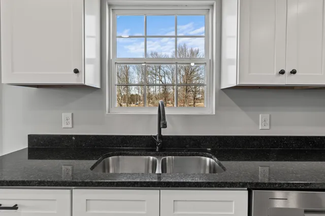 a bathroom with a granite countertop sink a toilet a mirror and bathtub