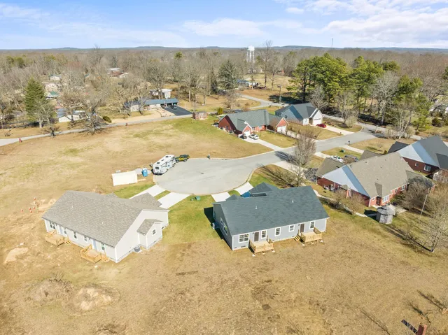 a view of an empty room with wooden floor and windows