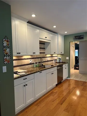 a large kitchen with stainless steel appliances granite countertop a stove and a sink