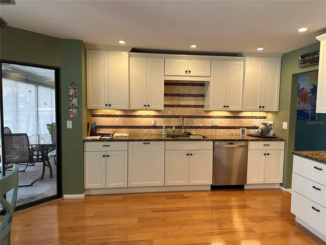 a kitchen with stainless steel appliances granite countertop a stove a sink and a refrigerator