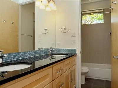a bathroom with a granite countertop sink toilet and shower