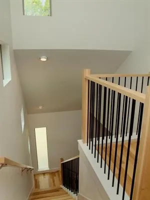 a view of staircase with railing and white walls