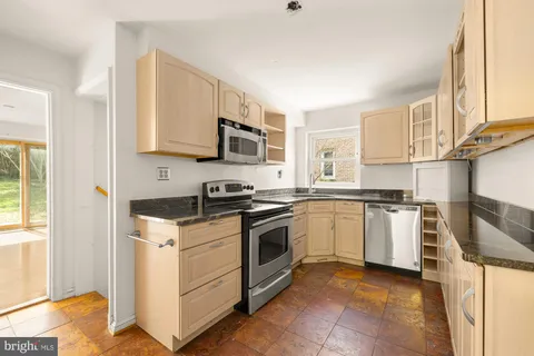 a kitchen with stainless steel appliances granite countertop a sink stove and microwave