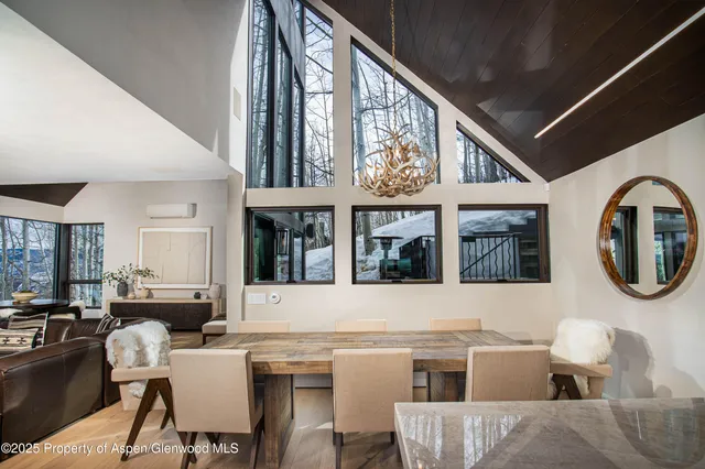 a kitchen with stainless steel appliances granite countertop a dining table chairs and a large window